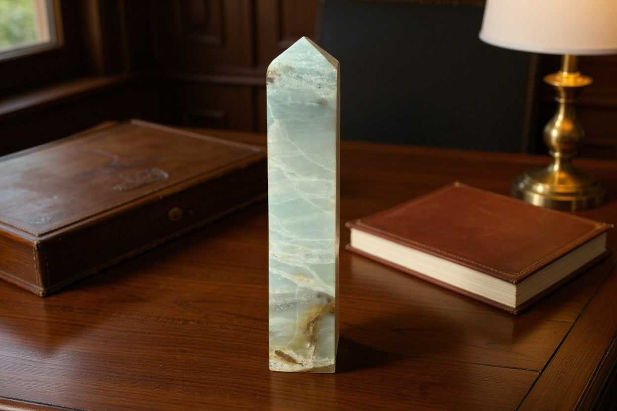 The Crystalary Caribbean Blue Calcite crystal tower with unique brown and white veining. Polished obelisk.